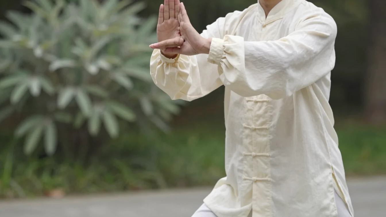 Close view of a practitioner's hands and posture during slow Qi G