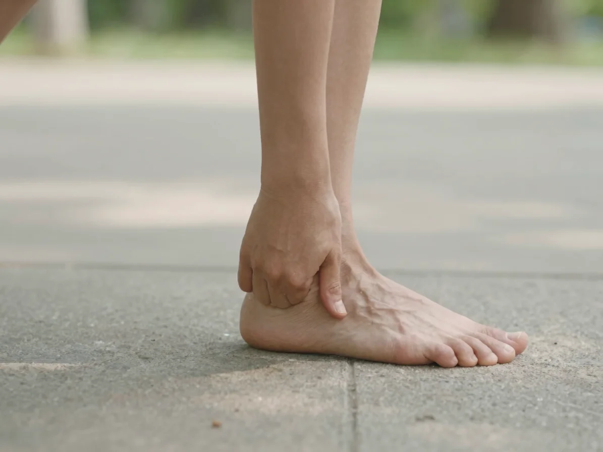 Natural editorial photograph of a close view of gentle ankle and wrist movement in outdoor practice, soft natural daylig